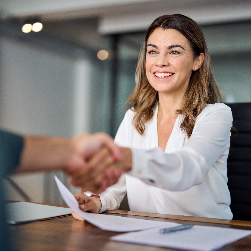 Happy mid aged business woman manager handshaking at office meeting. Smiling female hr hiring recruit at job interview, bank or insurance agent, lawyer making contract deal with client at work.